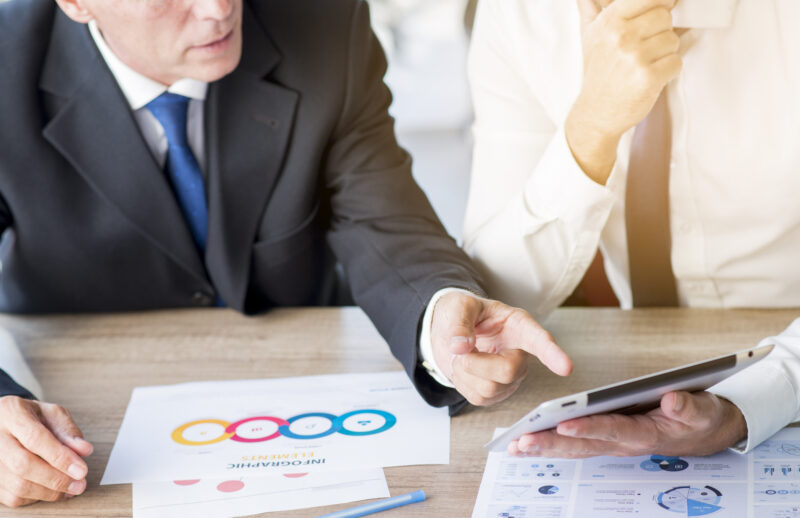 businessman pointing finger digital tablet hold by his partner workplace